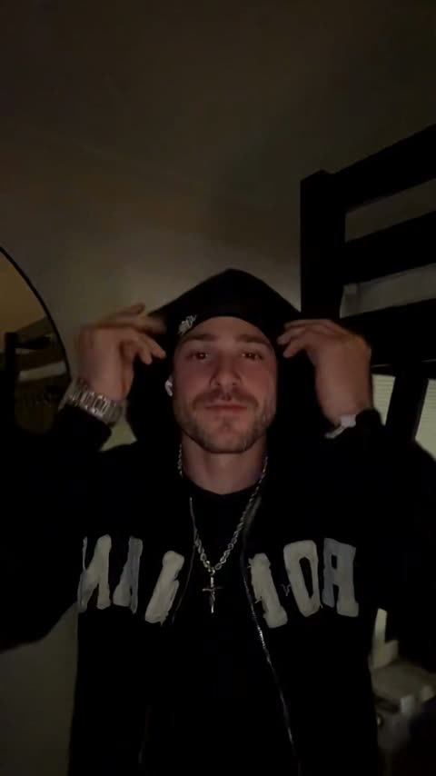 AI sample frame: black cap and hoodie in a dark room